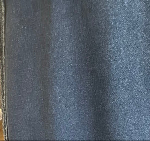Close-up of blue denim fabric with a visible seam.
